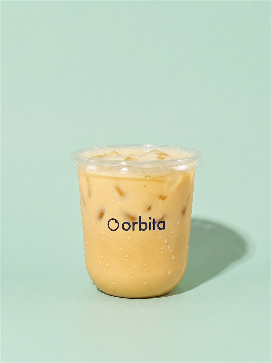 PINEAPPLE ESPRESSO, a pale golden shaken drink over ice, in a cup printed with the orbita logo